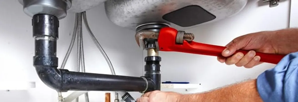 Garbage disposal repair technician tightening the sink drain and disposal connection in Memphis, TN
